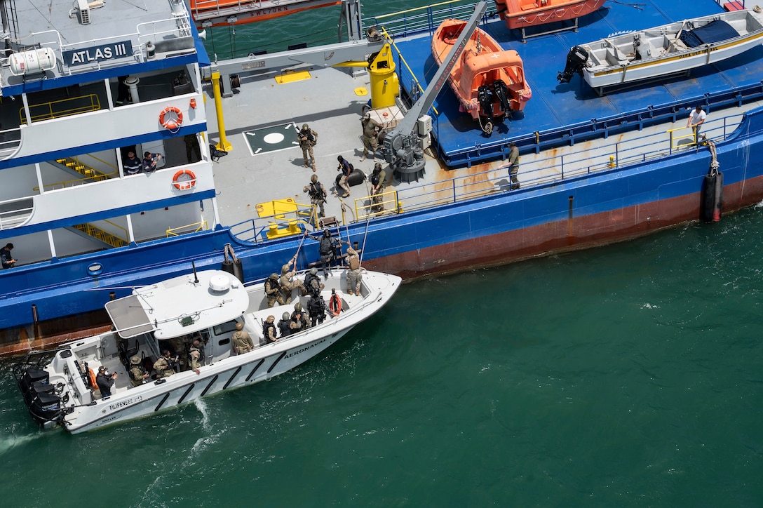Panamanian Servicio Nacional Aeronaval service members board a vessel for a simulated visit, board, search, and seizure training during PANAMAX-Alpha Phase I, at Panama City, Panama, July 16, 2025. PANAMAX is a joint exercise designed to enhance interoperability among participating nations and strengthen their ability to conduct multinational operations, particularly to defend the Panama Canal. (U.S. Air Force photo illustration by Staff Sgt. Sadie Colbert)