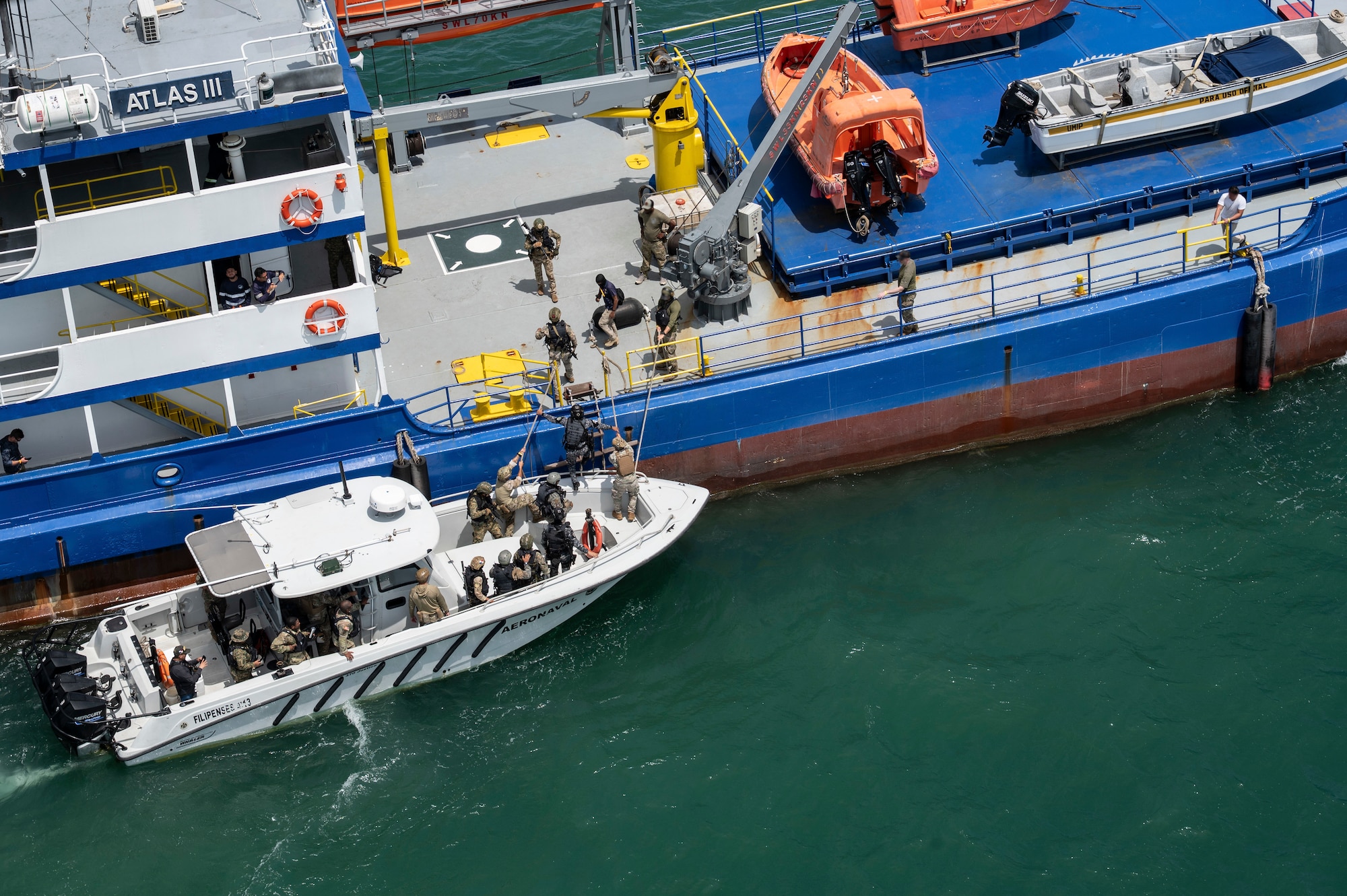 Panamanian Servicio Nacional Aeronaval service members board a vessel for a simulated visit, board, search, and seizure training during PANAMAX-Alpha Phase I, at Panama City, Panama, July 16, 2025. PANAMAX is a joint exercise designed to enhance interoperability among participating nations and strengthen their ability to conduct multinational operations, particularly to defend the Panama Canal. (U.S. Air Force photo illustration by Staff Sgt. Sadie Colbert)