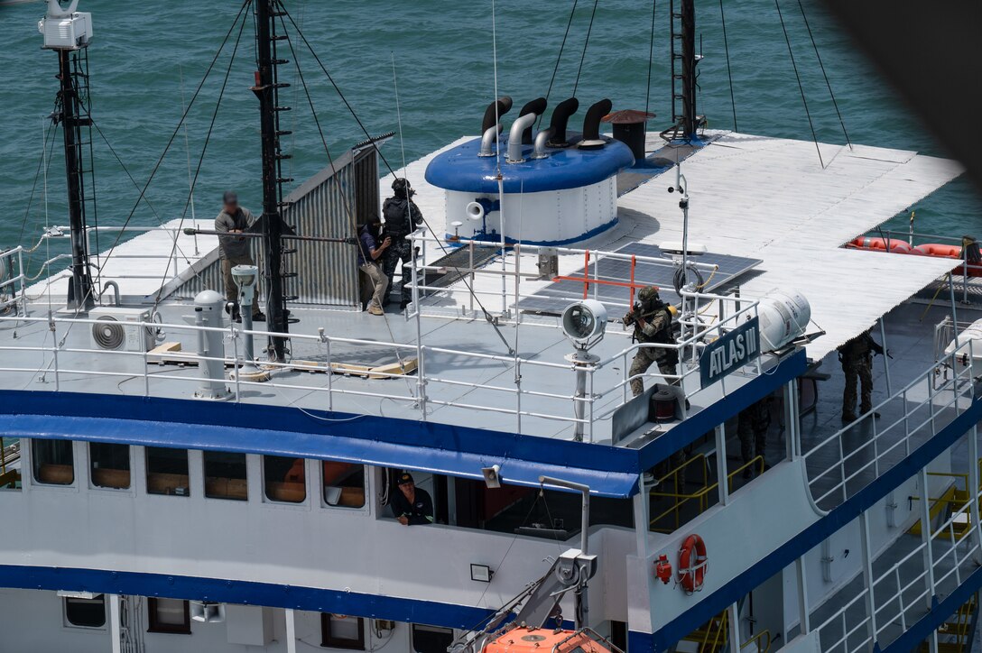 Panamanian special forces members clear a rooftop as a U.S. Naval Special Warfare operator observes during a simulated visit, board, search, and seizure training during PANAMAX-Alpha Phase I, at Panama City, Panama, July 16, 2025. PANAMAX-Alpha Phase I is a government of Panama exercise supported by U.S. Southern Command, focused on security of the canal in Panama. (U.S. Air Force photo illustration by Staff Sgt. Sadie Colbert)