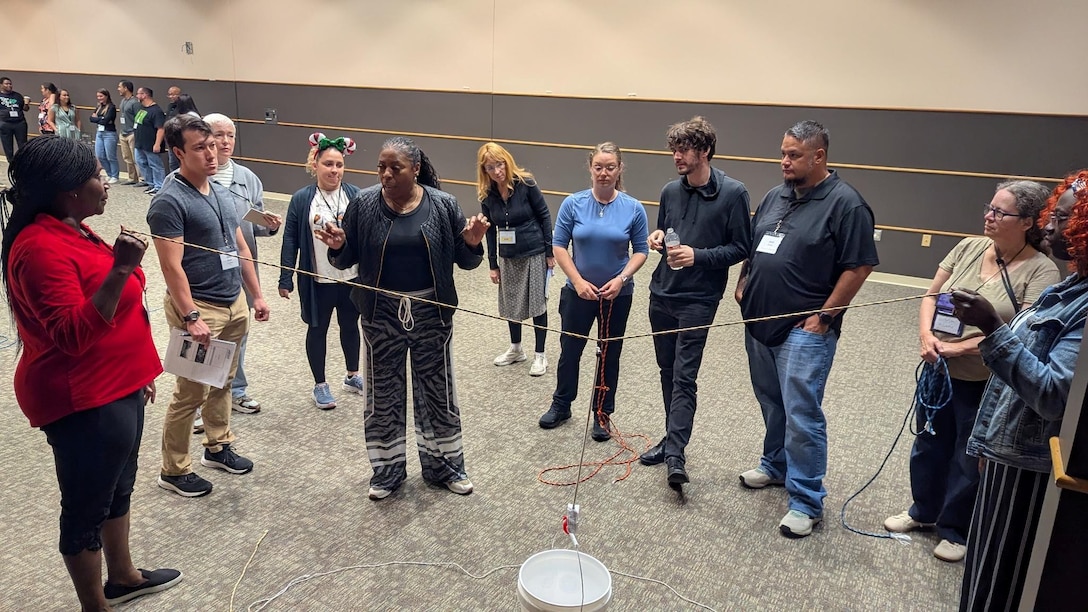 Defense Logistics Agency Financial Analyst Esther Ansah, left, participates in a trust building exercise with her peers at the Defense Civilian Emerging Leader Program