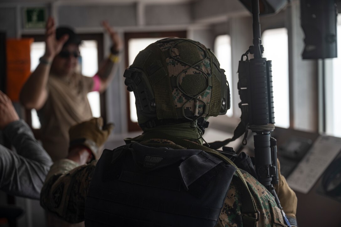 A Panamanian Servicio Nacionales de Fronteras (SENAFRONT) member helps detain simulated adversaries during a bilateral visit, board, search, and seizure training between U.S. and Panamanian special forces units, at Panama City, Panama, July 17, 2025. PANAMAX-Alpha Phase I is a government of Panama exercise supported by U.S. Southern Command, focused on security of the canal in Panama. (U.S. Air Force photo illustration by Staff Sgt. Sadie Colbert)