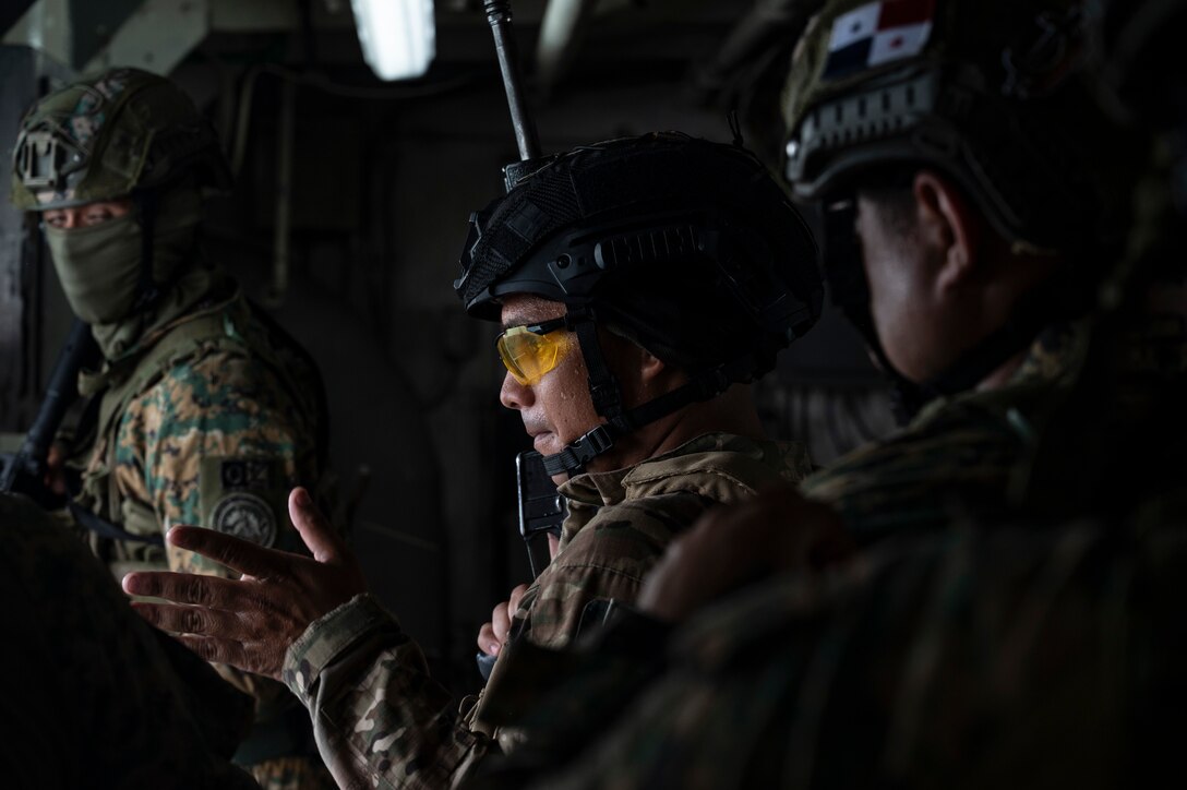 A Panamanian Servicio Nacionales de Fronteras (SENAFRONT) member motions his team to move forward during a simulated visit, board, search, and seizure training between U.S. and Panamanian special forces units, at Panama City, Panama, July 17, 2025. As part of PANAMAX-Alpha Phase I, the Government of Panama conducted unilateral, simulated Panama Canal security operations, supported by U.S. Southern Command. This phase includes Military Decision-Making Process (MDMP) academics, a command post exercise (CPX), and a field training exercise (FTX). (U.S. Air Force photo by Staff Sgt. Sadie Colbert)