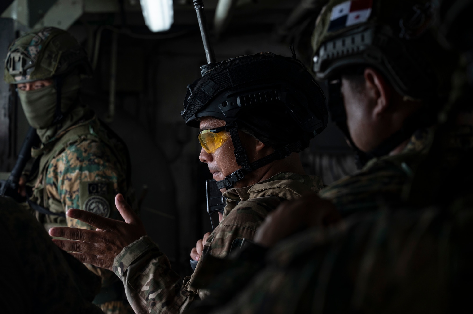 A Panamanian Servicio Nacionales de Fronteras (SENAFRONT) member motions his team to move forward during a simulated visit, board, search, and seizure training between U.S. and Panamanian special forces units, at Panama City, Panama, July 17, 2025. As part of PANAMAX-Alpha Phase I, the Government of Panama conducted unilateral, simulated Panama Canal security operations, supported by U.S. Southern Command. This phase includes Military Decision-Making Process (MDMP) academics, a command post exercise (CPX), and a field training exercise (FTX). (U.S. Air Force photo by Staff Sgt. Sadie Colbert)