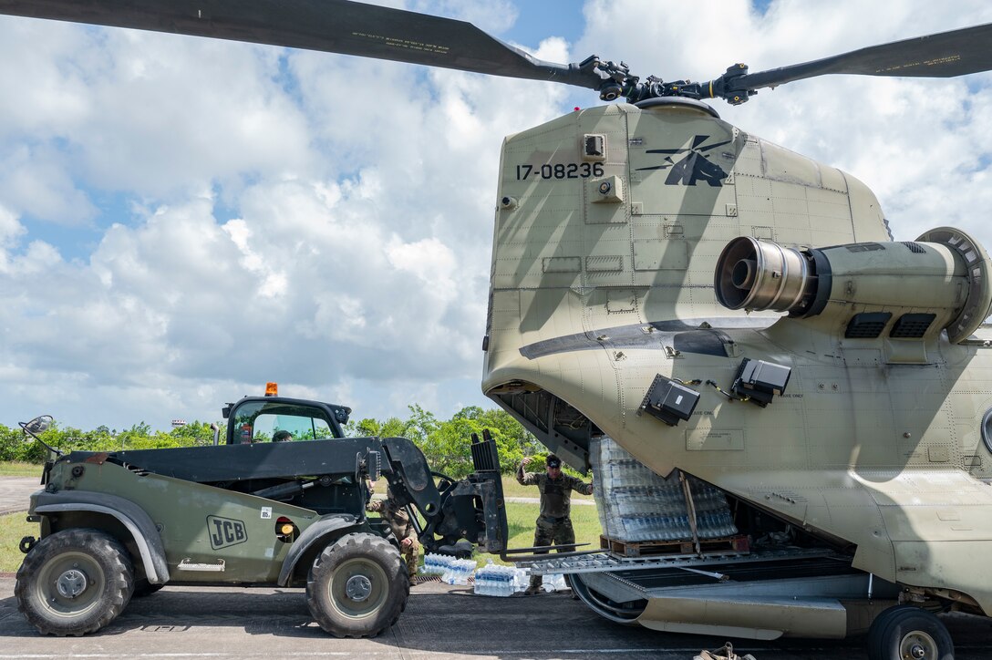 U.S. Army Staff Sgt. Jordan England, 1st Battalion, 228th Aviation Regiment, crew non-commissioned officer in charge, guides a forklift to a water supply on a CH-47 Chinook in Belize City, Belize, July 31, 2025. Exercises like AGILE BEAR increase our shared readiness to respond to natural disasters and security challenges through multifaceted capabilities ensuring our strength through unity and solidifying U.S. Southern Command's Joint Task Force-Bravo, as the partner of choice in Central America. (U.S. Air Force photo by Staff Sgt. Sadie Colbert)