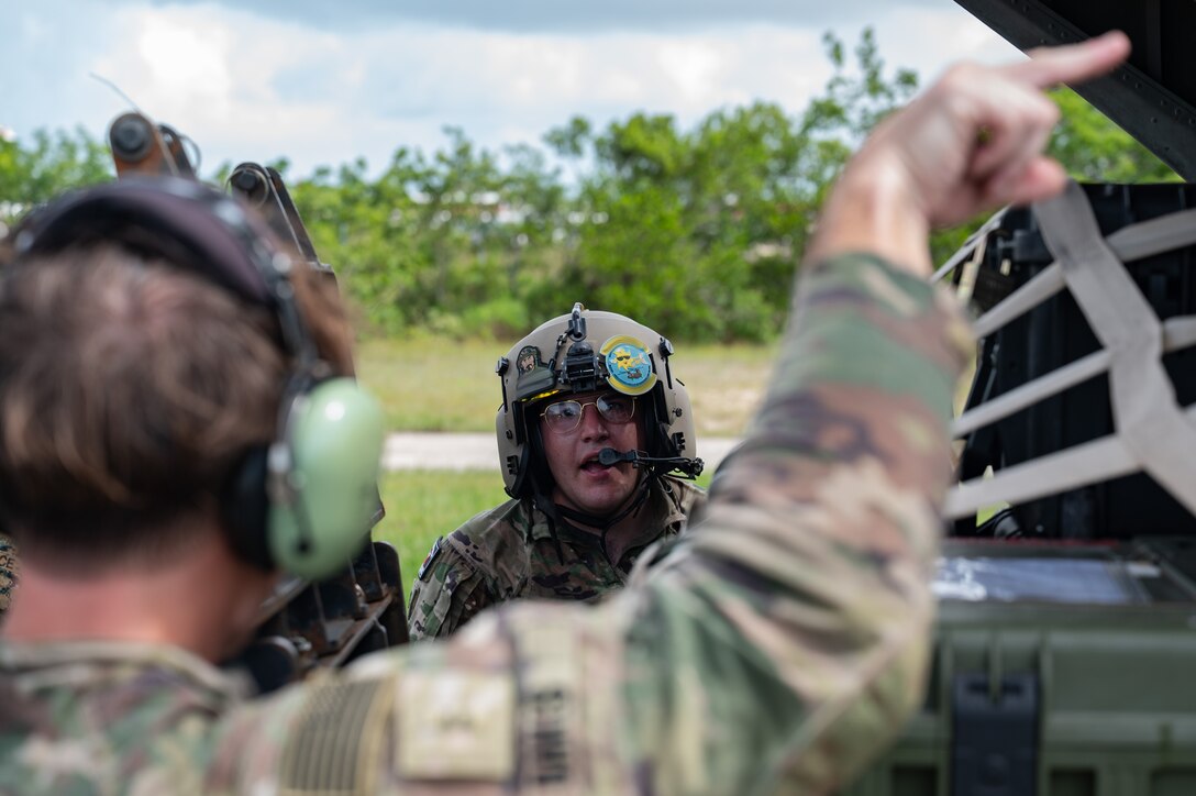U.S. Army Sgt. Griffin Paul, 1st Battalion, 228th Aviation Regiment crew chief assists guiding a forklift at Belize City, Belize, July 31, 2025. Given Central America's high vulnerability to natural disasters, Joint Task Force-Bravo's AGILE BEAR exercise works collaboratively with the British Army Training Support Unit-Belize, Belize Defence Force and Belize Coast Guard to conduct  subject matter expert exchanges equipping our forces with the necessary knowledge and resources to lessen the impact of these events. (U.S. Air Force photo illustration by Staff Sgt. Sadie Colbert)