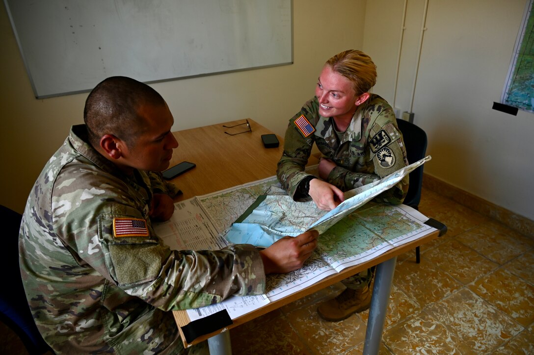 U.S. Army Staff Sgt. Gabriel Reynoso, left, and 2nd Lt. Caitlyn Curmode, Southern Command Situational Assessment team members, discuss operations during AGILE BEAR 25, at Belize City, Belize, July 31, 2025. Given Central America's high vulnerability to natural disasters, Joint Task Force-Bravo's AGILE BEAR exercise works collaboratively with the British Army Training Support Unit-Belize, Belize Defence Force and Belize Coast Guard to conduct  subject matter expert exchanges equipping our forces with the necessary knowledge and resources to lessen the impact of these events. (U.S. Air Force photo by Capt. Katelin Robinson)
