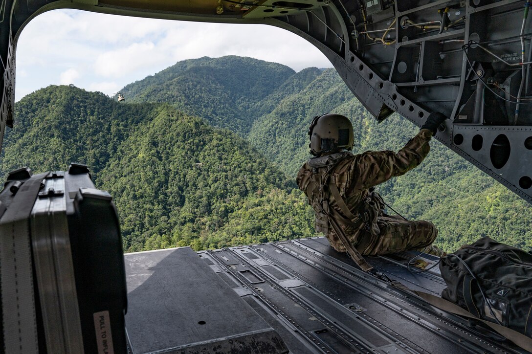 U.S. Army Sgt. Gabe Lucero, 1st Battalion, 228th Aviation Regiment crew chief, performs a flight observation in a CH-47 Chinook in Honduras, July 31, 2025. Joint Task Force-Bravo's helicopter activities, in collaboration with host nation and NATO military partners, showcase their unique ability to perform search and rescue operations and deliver humanitarian aid to remote environments. (U.S. Air Force photo by Staff Sgt. Sadie Colbert)