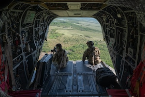 U.S. Army Joint Task Force-Bravo J7 member, left, takes a photo while a CH-47 Chinook crew chief, 1st Battalion, 228th Aviation Regiment, observes in a CH-47 Chinook in Belize during exercise AGILE BEAR, August 2, 2025. Exercises like AGILE BEAR increase our shared readiness to respond to natural disasters and security challenges through multifaceted capabilities ensuring our strength through unity and solidifying U.S. Southern Command's Joint Task Force-Bravo, as the partner of choice in Central America. (U.S. Air Force photo by Staff Sgt. Sadie Colbert)