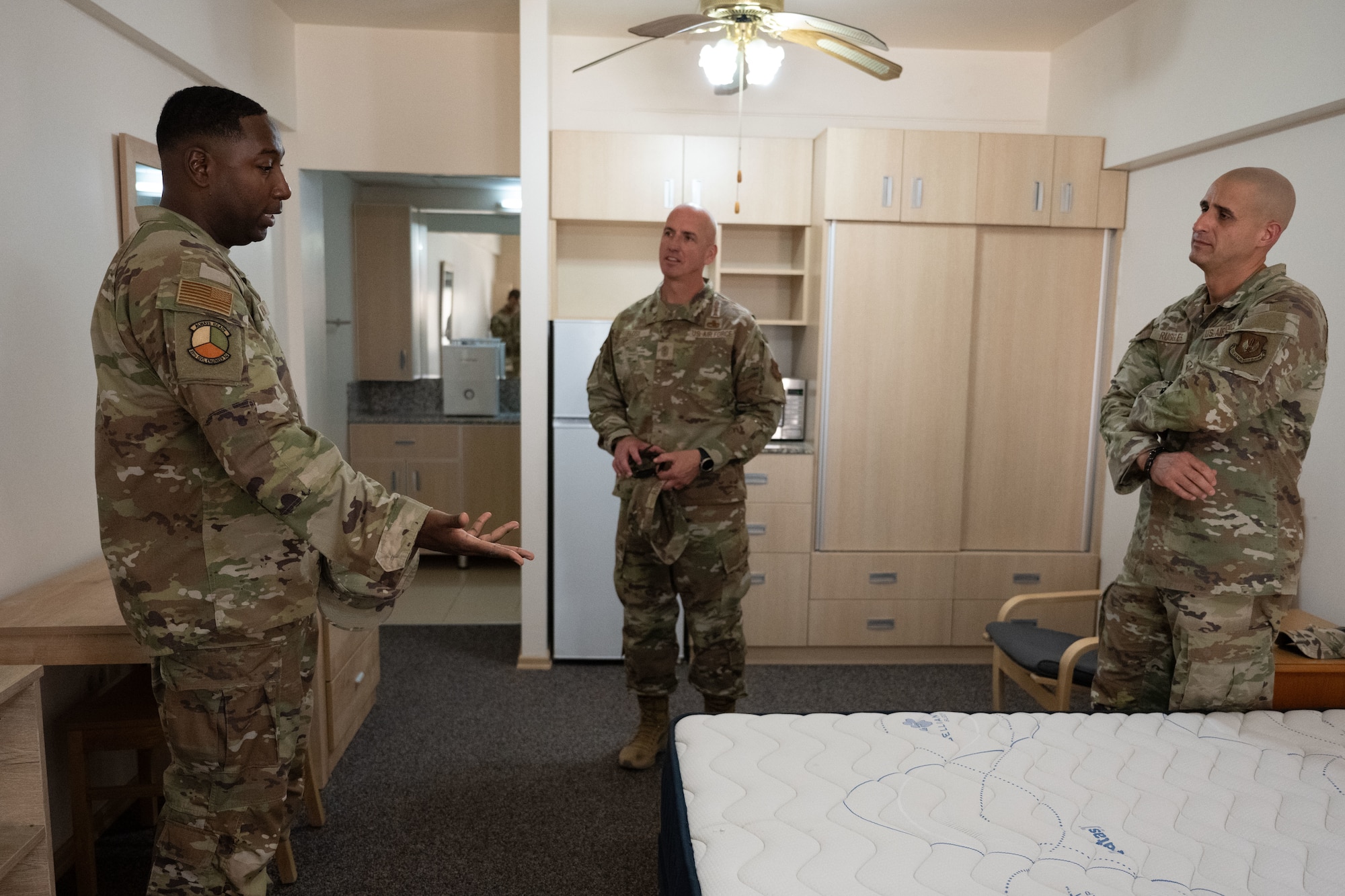 U.S. Air Force Staff Sgt. Robert Smith, left, 39th Civil Engineer Squadron Airmen Dorm Leader, briefs Chief Master Sgt. of the Air Force David Flosi, center, about dorm renovations, during his visit to Incirlik Air Base, Türkiye, August 14, 2025.