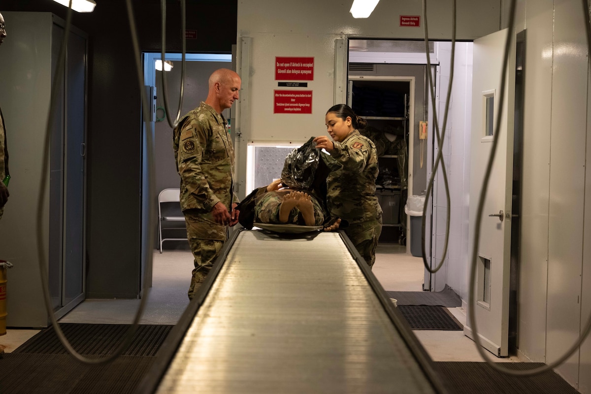 Chief Master Sgt. of the Air Force David Flosi, observes U.S. Air Force Staff Sgt. Janely Lira, 39th Medical Group in-place patient decontamination team chief, conduct a decontamination process during his visit to Incirlik Air Base, Türkiye, August 14, 2025.
