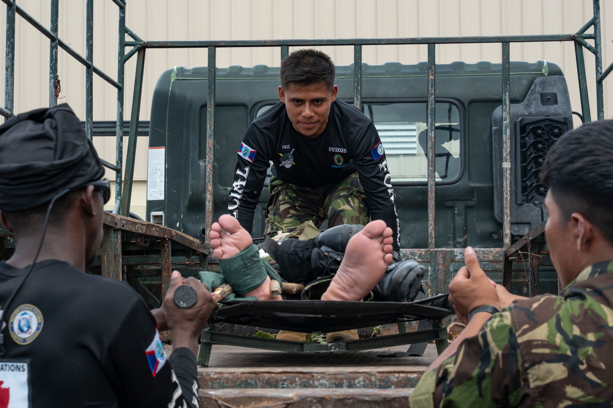 Belize Defence Force members practice loading a patient onto a vehicle during the tactical combat casualty care subject matter expert exchange for AGILE BEAR 25, Belize City, Belize, Aug. 4, 2025. AGILE BEAR, led by Joint Task Force-Bravo provides critical subject matter expert exchanges in disaster response and counter transnational criminal organization activities preparing U.S. Southern Command’s Situational Assessment Team, 1st Battalion, 228th Aviation Regiment, and Belize and NATO partners for a collaborative response in times of crises. (U.S. Air Force photo by Staff Sgt. Sadie Colbert)