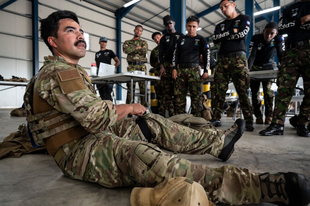 U.S. Air Force Tech. Sgt. Daniel Rodriguez, 100th Operation Support Squadron survival, resistance, evasion and escape instructor out of Mildenhall Air Force Base, England, demonstrates how to use a tourniquet as Belize Defence Force and Belize Coast Guard members observe, during exercise AGILE BEAR 25, Belize City, Belize, Aug. 4, 2025. AGILE BEAR, led by Joint Task Force-Bravo provides critical subject matter expert exchanges in disaster response and counter transnational criminal organization activities preparing U.S. Southern Command’s Situational Assessment Team, 1st Battalion, 228th Aviation Regiment, and Belize and NATO partners for a collaborative response in times of crises. (U.S. Air Force photo by Staff Sgt. Sadie Colbert)