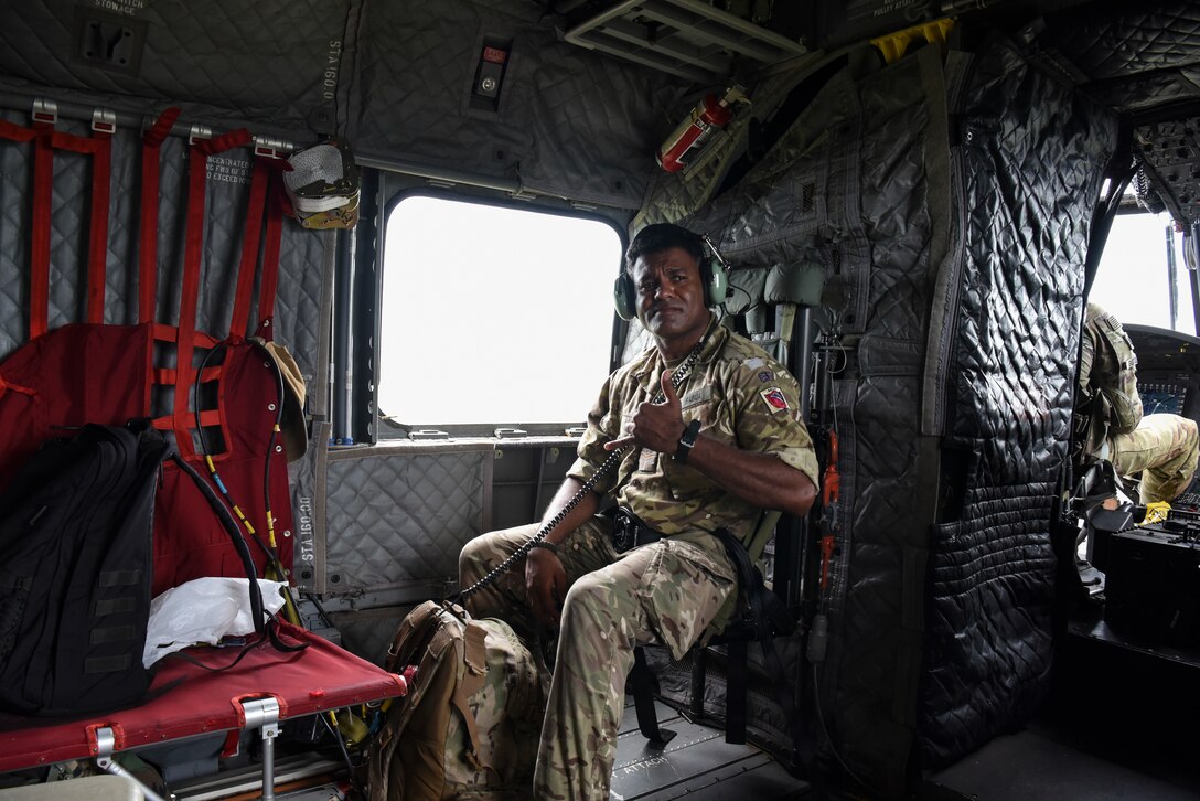A British Army Training Support Unit Belize (BATSUB) member poses for a photo on a CH-47 Chinook during exercise AGILE BEAR 25, Belize City, Belize, Aug. 5, 2025. The exercise aims to strengthen the readiness of U.S. and partner nation forces to respond effectively during a disaster and in countering transnational criminal organizations through various subject matter expert exchanges and events. Key participants include Joint Task Force-Bravo, Belize Coast Guard, BDF, U.S. Embassy-Belize, and the BATSUB. (U.S. Air Force photo by Tech. Sgt. Dylan Rossitto)