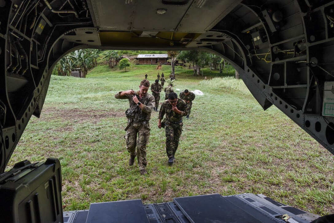A British Army Training Support Unit Belize, (BATSUB) (left), and Belize Defence Force (BDF) member return to a CH-47 Chinook during exercise AGILE BEAR 25, in Belize, Aug. 5, 2025. As U.S. Southern Command’s rapid response element in Central America, JTF-Bravo provides a unique and essential capability in enabling our partner nations to proactively confront threats to their security with exercises like AGILE BEAR, preparing our teams to respond to crises in the joint operational area. (U.S. Air Force photo by Tech. Sgt. Dylan Rossitto)
