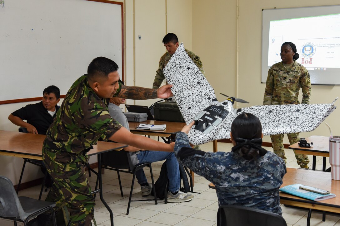 Belize Defence Force and Belize Coast Guard members look at a small, unmanned aircraft system (sUAS) during exercise AGILE BEAR 25, Belize City, Belize, Aug. 4, 2025. During the course, participants learned about the advantages and uses of sUASs, aiding in the collection of data without putting service members in harm’s way. AGILE BEAR, led by Joint Task Force-Bravo provides critical subject matter expert exchanges in disaster response and counter transnational criminal organization activities preparing U.S. Southern Command’s Situational Assessment Team, 1st Battalion, 228th Aviation Regiment, and Belize and NATO partners for a collaborative response in times of crises. (U.S. Air Force photo by Tech. Sgt. Dylan Rossitto)