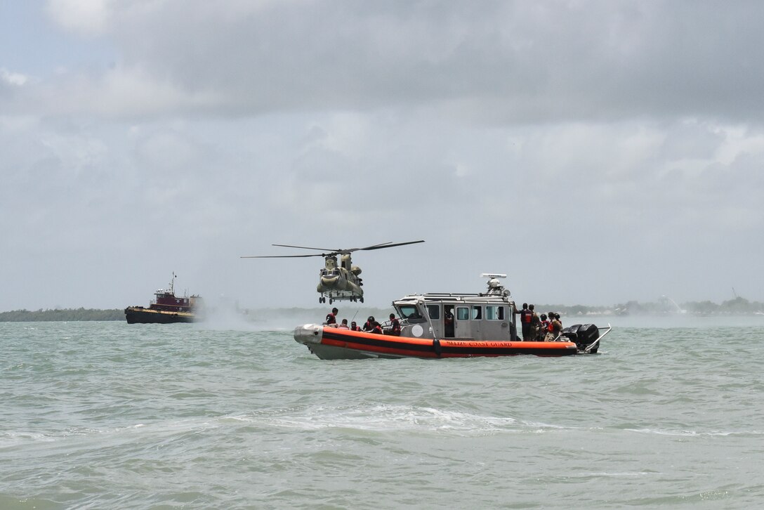 A CH-47 Chinook flies near a Belize Defence Force safety boat prior to helocast practice as part of exercise AGILE BEAR 25, Aug. 6, 2025. As U.S. Southern Command’s rapid response element in Central America, Joint Task Force-Bravo provides a unique and essential capability in enabling our partner nations to proactively confront threats to their security through exercises like AGILE BEAR, preparing our teams to respond to crises in the joint operational area. (U.S. Air Force photo by Tech. Sgt. Dylan Rossitto)