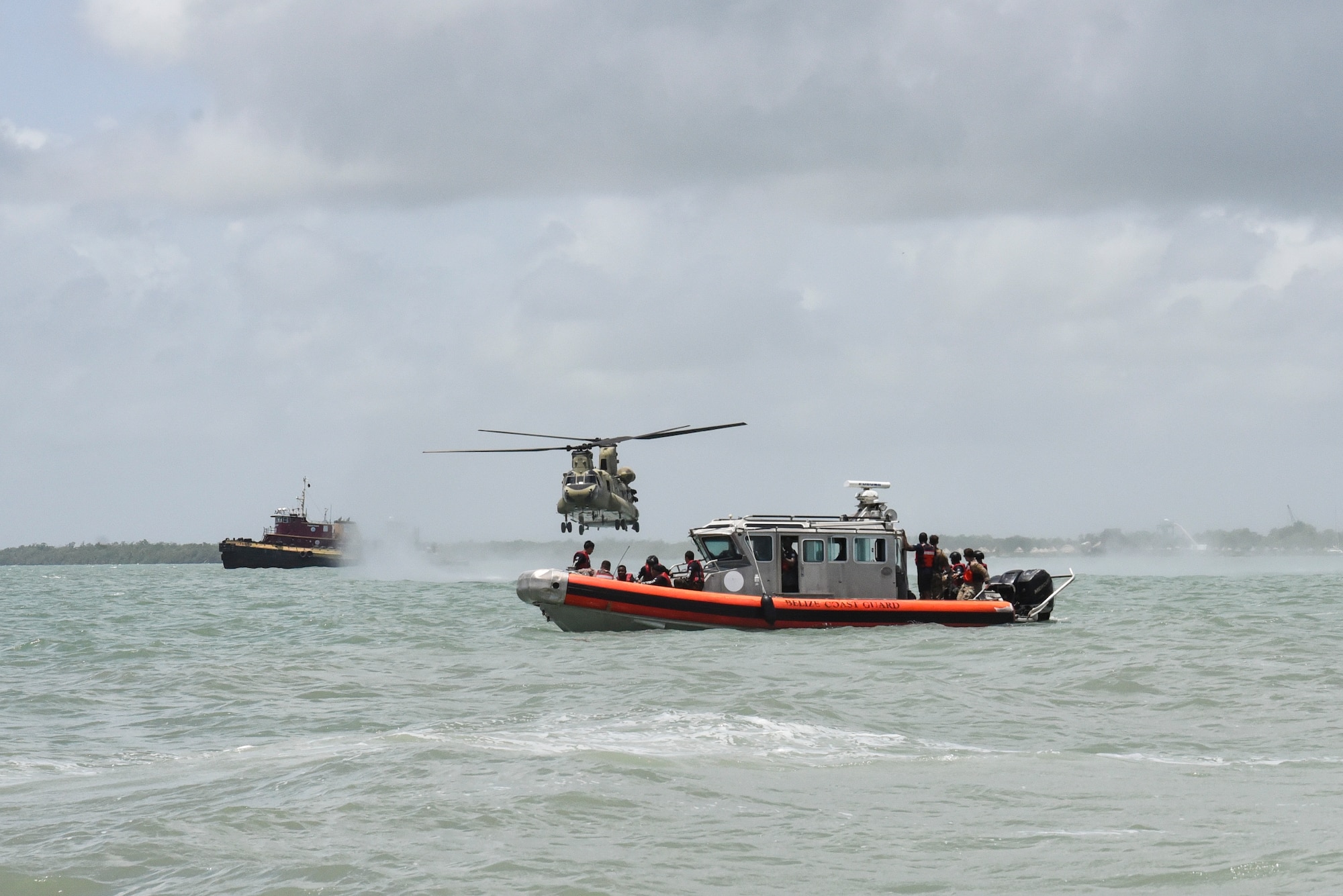 A CH-47 Chinook flies near a Belize Defence Force safety boat prior to helocast practice as part of exercise AGILE BEAR 25, Aug. 6, 2025. As U.S. Southern Command’s rapid response element in Central America, Joint Task Force-Bravo provides a unique and essential capability in enabling our partner nations to proactively confront threats to their security through exercises like AGILE BEAR, preparing our teams to respond to crises in the joint operational area. (U.S. Air Force photo by Tech. Sgt. Dylan Rossitto)
