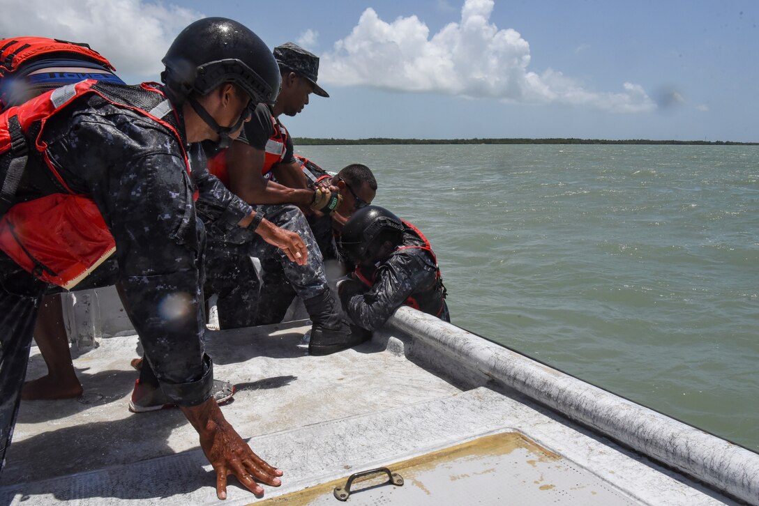 Belize Coast Guard members help a member onto a vessel during helocast practice at exercise AGILE BEAR 25, Belize City, Belize, Aug. 6, 2025. As U.S. Southern Command’s rapid response element in Central America, Joint Task Force-Bravo provides a unique and essential capability in enabling our partner nations to proactively confront threats to their security through exercises like AGILE BEAR, preparing our teams to respond to crises in the joint operational area. (U.S. Air Force photo by Tech. Sgt. Dylan Rossitto)