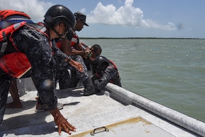 Belize Coast Guard members help a member onto a vessel during helocast practice at exercise AGILE BEAR 25, Belize City, Belize, Aug. 6, 2025. As U.S. Southern Command’s rapid response element in Central America, Joint Task Force-Bravo provides a unique and essential capability in enabling our partner nations to proactively confront threats to their security through exercises like AGILE BEAR, preparing our teams to respond to crises in the joint operational area. (U.S. Air Force photo by Tech. Sgt. Dylan Rossitto)