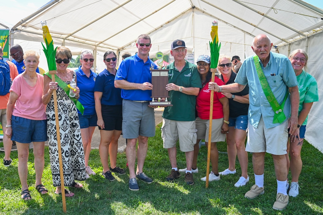 Corn eating contest participants from the 88th Air Base Wing and the Fairborn city council hold up a trophy.