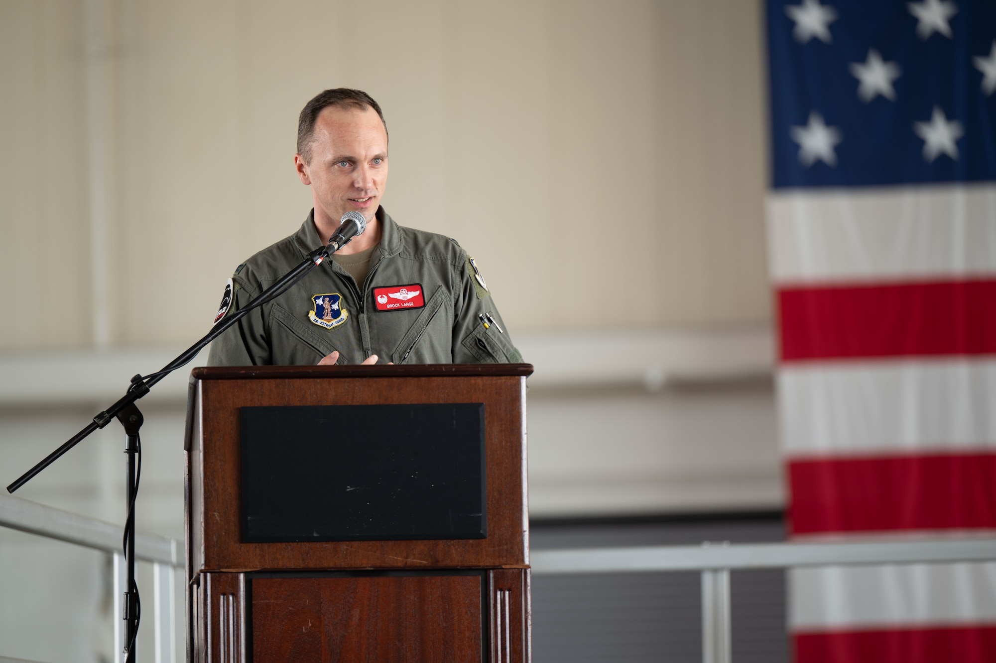 Col. Brock E. Lange, 192nd Wing commander, stands at a podium