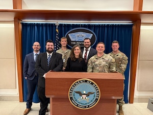 Individuals standing by podium that says The Pentagon