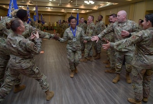 A woman in military uniforms gives high-fives to people