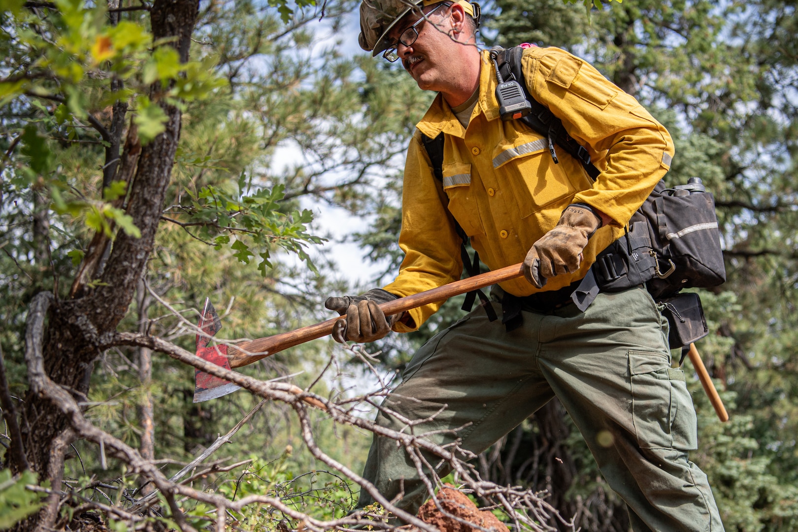Staff Sgt. Jonathan Sabala, an infantryman assigned to the Oklahoma Army National Guard’s 1st Battalion, 279th Infantry Regiment, 45th Infantry Brigade Combat Team and a member of the OKNG wildland firefighting program, clears trees that could fuel a fire during an operational readiness exercise at Camp Navajo, Arizona, Aug. 13, 2025. The operational readiness exercise tests the OKNG members’ ability to activate, deploy and conduct wildland firefighting operations. (Oklahoma National Guard photo by Staff Sgt. Anthony Jones)
