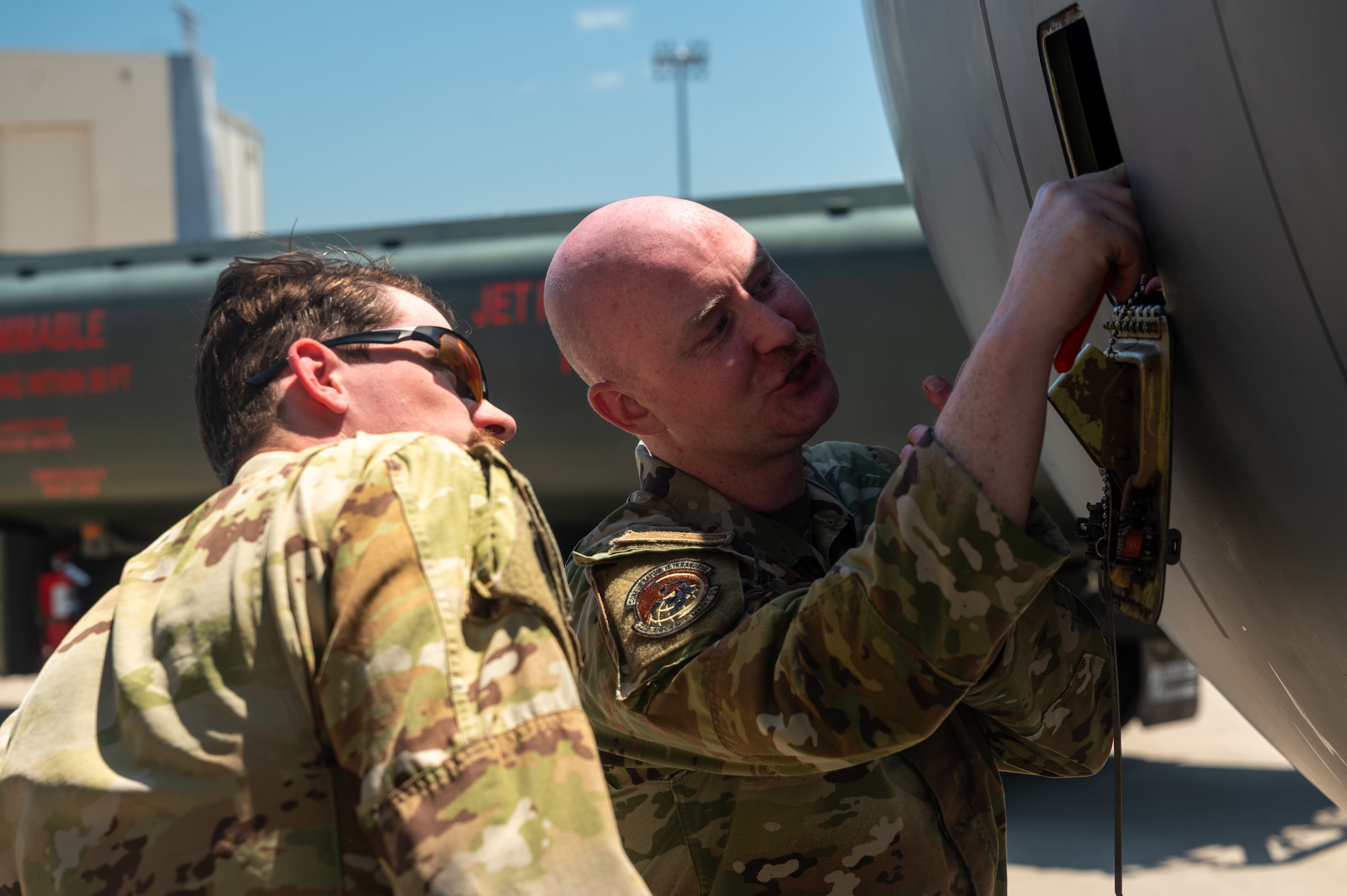 U.S. Air Force Senior Airman Allen White, 722nd Aircraft Maintenance Squadron crew chief, demonstrates procedures for servicing the engine oil of a KC-135 Stratotanker aircraft to Staff Sgt. Benjamin Fedrick, 350th Air Refueling Squadron boom operator, at McConnell Air Force Base, Kansas, July 8, 2025. Operators and pilots were instructed on basic maintenance procedures as they provided critical air refueling support to the Air Force's 2025 Department-Level Exercise series. The DLE series encompasses all branches of the Department of Defense, along with Allies and partners, employing more than 400 Joint and coalition aircraft and more than 12,000 members at more than 50 locations across 3,000 miles (U.S. Air Force photo by Tech. Sgt. Nathan Eckert)