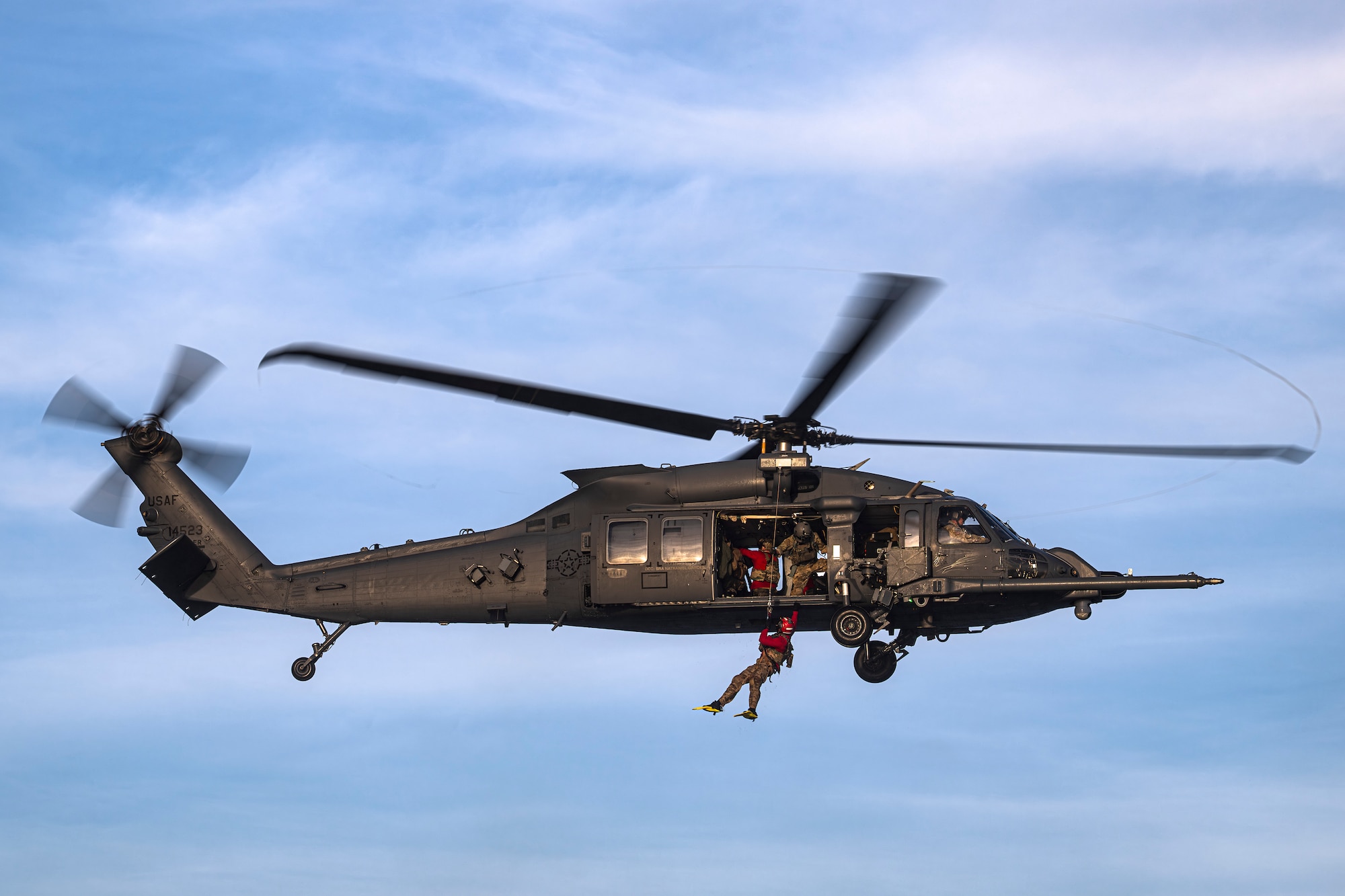 photo depicting people being hoisted into a helicopter