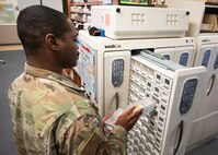 An Airman stores away filled medications.