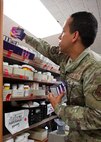 An Airman checks the expiration dates on medication.