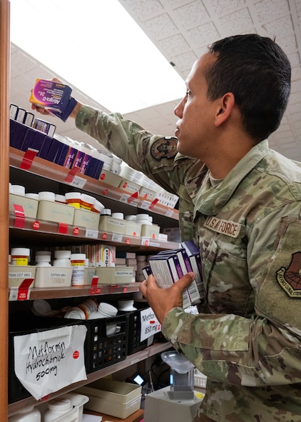 An Airman checks the expiration dates on medication.