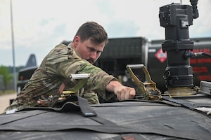 A service member works on a fuel bladder.