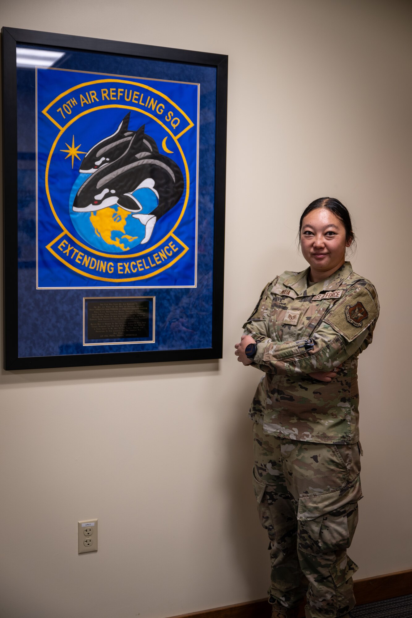U.S. Air Force Staff Sgt. Michelle Moua, a Squadron Aviation Resource Management specialist assigned to the 70th Aerial Refueling Squadron, poses for a photo in front of a 70th ARS emblem at Travis AFB, Calif., August 20, 2025. Moua was recognized with the American Red Cross Service to Armed Forces Award on June 7, 2025 for her volunteer work at David Grant Medical Center. She also recently completed a Master's Degree in Public Health Administration and continues to serve with excellence as a Reserve Airman in the Air Force Reserve.