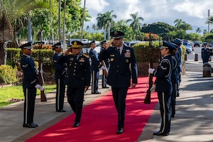 Gen. Kevin B. Schneider, Commander of Pacific Air Forces, and Air Chief Marshal Panthpakdee Pattanakul, Commander of the Royal Thai Air Force (RTAF), salute an honor cordon entering Pacific Air Force Headquarters, Joint Base Pearl-Harbor Hickam, Aug. 18, 2025.