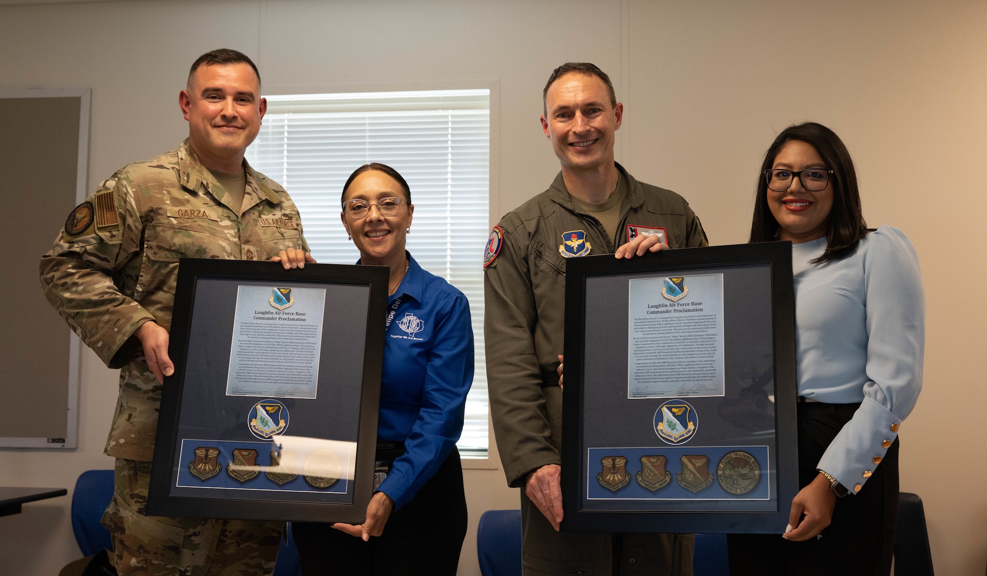 U.S. Air Force Chief Master Sgt. Erik Garza, 47th Flying Training Wing command chief, and Col. Tyler Ellison, 47th FTW commander, present commander proclamations to Aurora Guerra, Roberto” Bobby” Barrera Elementary STEM Magnet School principal, and Janette Gomez, RBB Elementary School liaison program manager, at Laughlin Air Force Base, Texas, Aug. 18, 2025.  Team XL leadership gathered to recognize RBB Elementary School for becoming a 2025 Blue Ribbon Lighthouse School. (U.S. Air Force photo by Airman 1st Class Darryl Keith)