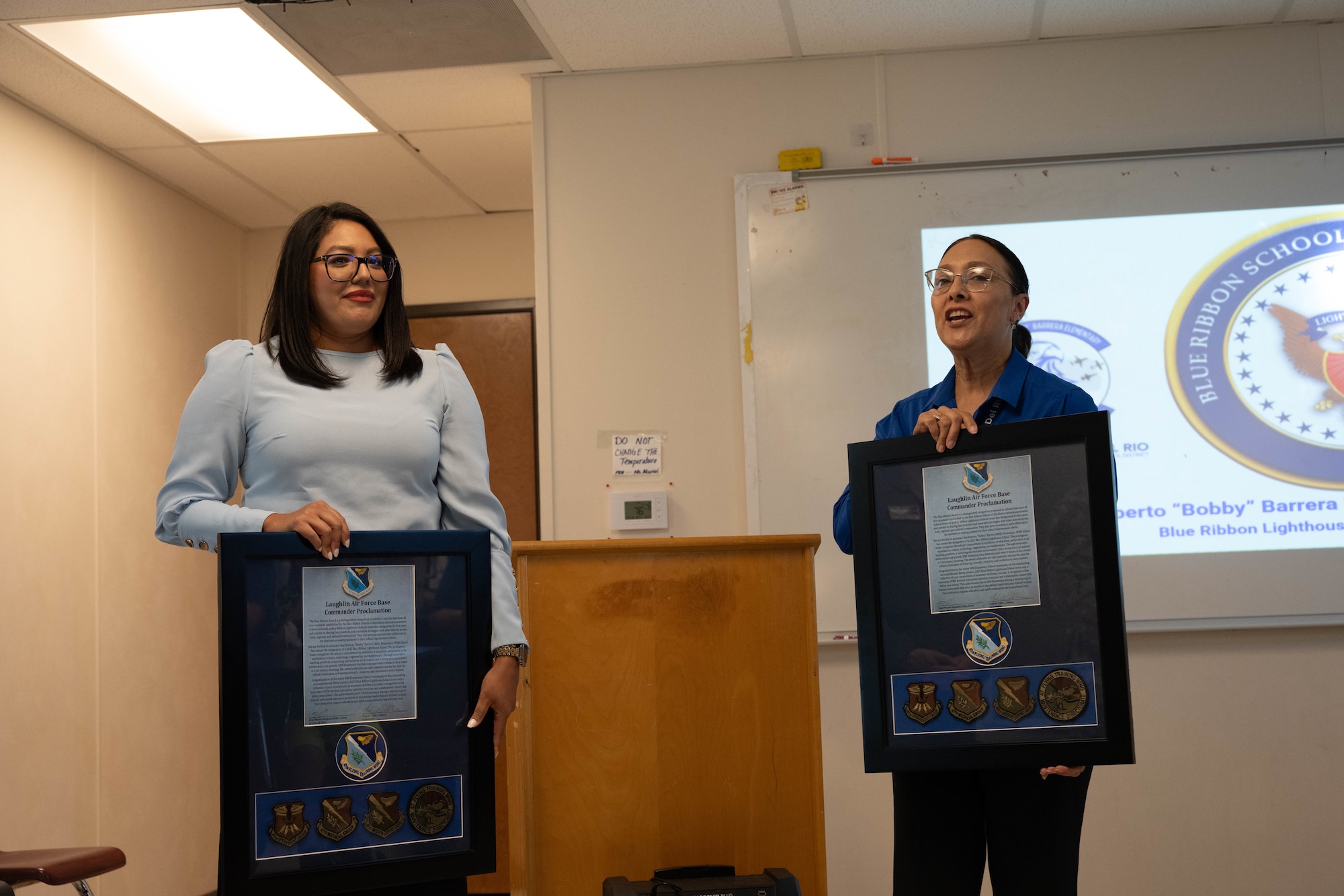 Janette Gomez, Laughlin Air Force Base School Liaison, and Aurora Guerra, Roberto ”Bobby” Barrera Elementary STEM Magnet School principle, speaks at RBB’s Blue Ribbon Lighthouse School award ceremony at Laughlin AFB, Texas, Aug. 18, 2025.  RBB was recognized by 47th Flight Training Wing leadership for being named a 2025 a 2025 Blue Ribbon Lighthouse School. (U.S. Air Force photo by Airman 1st Class Darryl Keith)