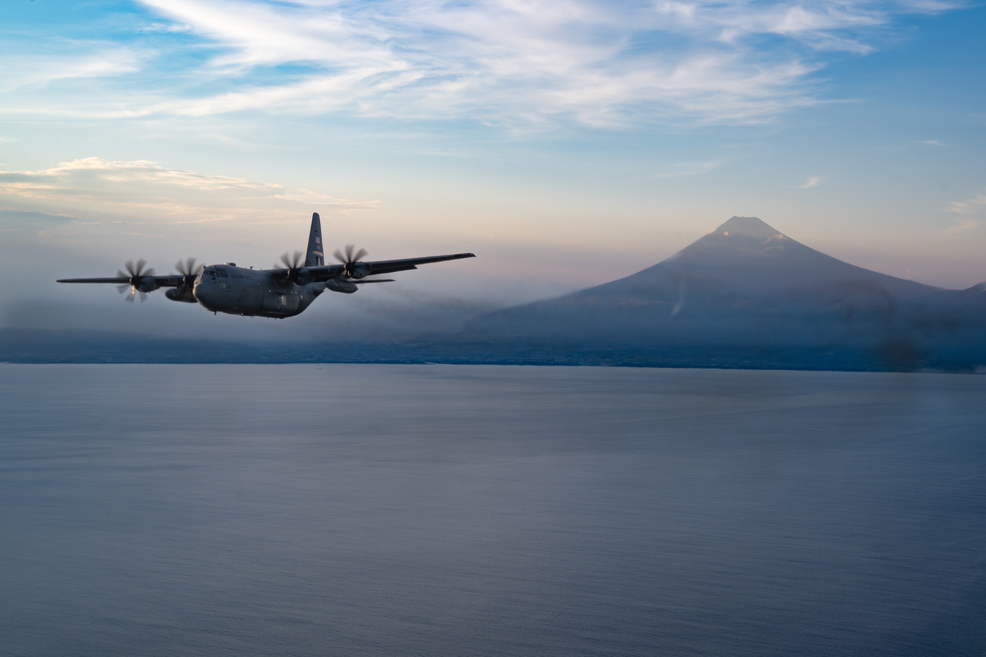 A U.S. Air Force C-130H3 Hercules aircraft, assigned to the 700th Airlift Squadron, Dobbins Air Reserve Base, Georgia, with a tail insignia known as the “The Big Square A” flies away from Mount Fuji, Japan after airdrop operations, July 28, 2025.