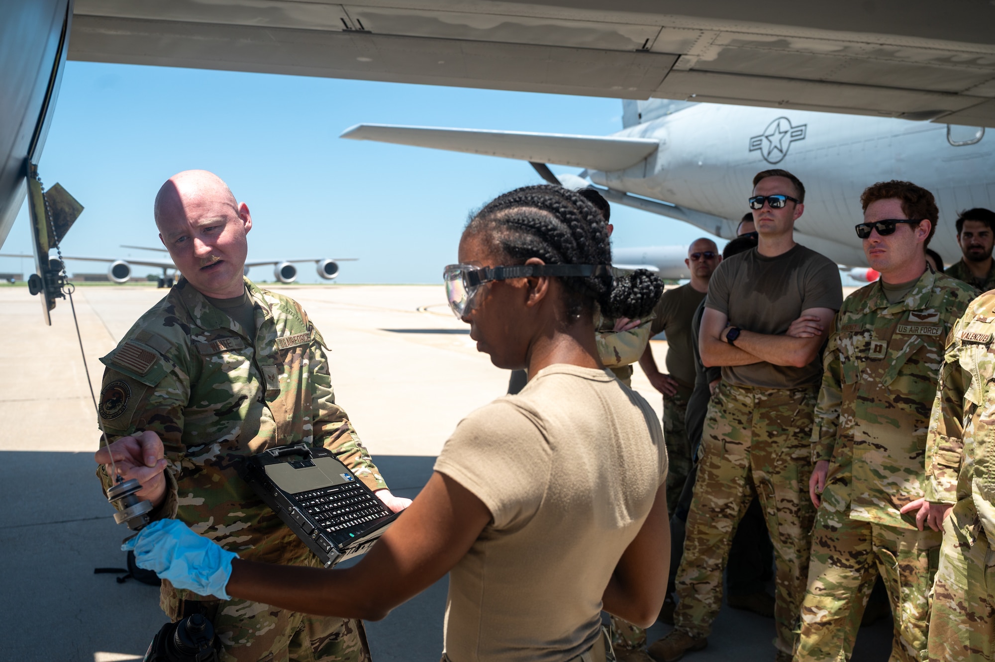 U.S. Air Force Senior Airman Allen White and Airman 1st Class Arianna Owen, 722nd Aircraft Maintenance Squadron crew chiefs, demonstrate procedures for servicing the engine oil of a KC-135 Stratotanker aircraft to pilots and boom operators assigned to the 22nd Air Refueling Wing at McConnell Air Force Base, Kansas, July 8, 2025. The operators were instructed on basic maintenance procedures as they provided critical air refueling support to the Air Force's 2025 Department-Level Exercise series. The DLE series encompasses all branches of the Department of Defense, along with Allies and partners, employing more than 400 Joint and coalition aircraft and more than 12,000 members at more than 50 locations across 3,000 miles (U.S. Air Force photo by Tech. Sgt. Nathan Eckert)