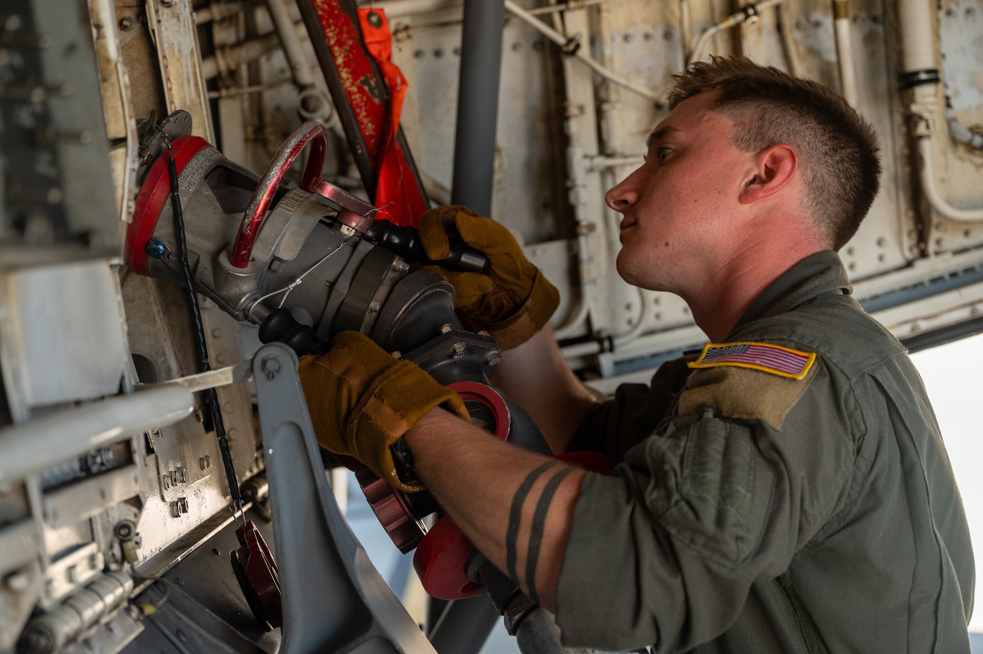 U.S. Air Force Airman 1st Class Connor Aversa, 350th Air Refueling Squadron boom operator, connects a fuel hose to a KC-135 Stratotanker aircraft at McConnell Air Force Base, Kansas, July 8, 2025. While ground fueling is typically conducted by logistics Airmen, boom operators were instructed on fueling and basic maintenance procedures as they provided critical air refueling support to the Air Force's 2025 Department-Level Exercise series. The DLE series encompasses all branches of the Department of Defense, along with Allies and partners, employing more than 400 Joint and coalition aircraft and more than 12,000 members at more than 50 locations across 3,000 miles (U.S. Air Force photo by Tech. Sgt. Nathan Eckert)