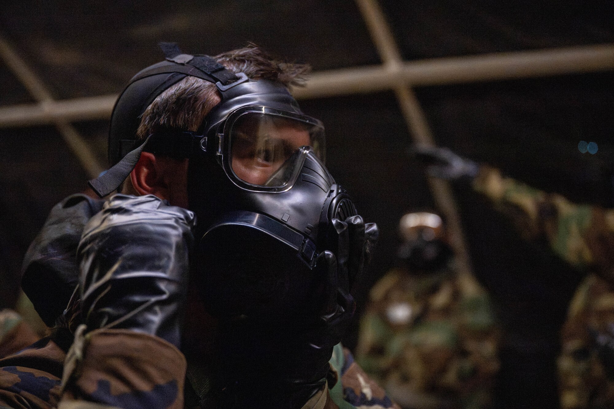 Airman puts on a gas mask.
