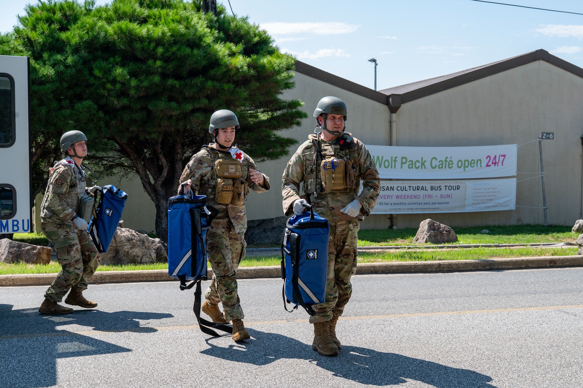 3 combat medics walk out of the back of an ambulance in a line
