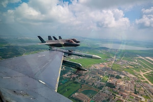 Three jets flying next to another over land