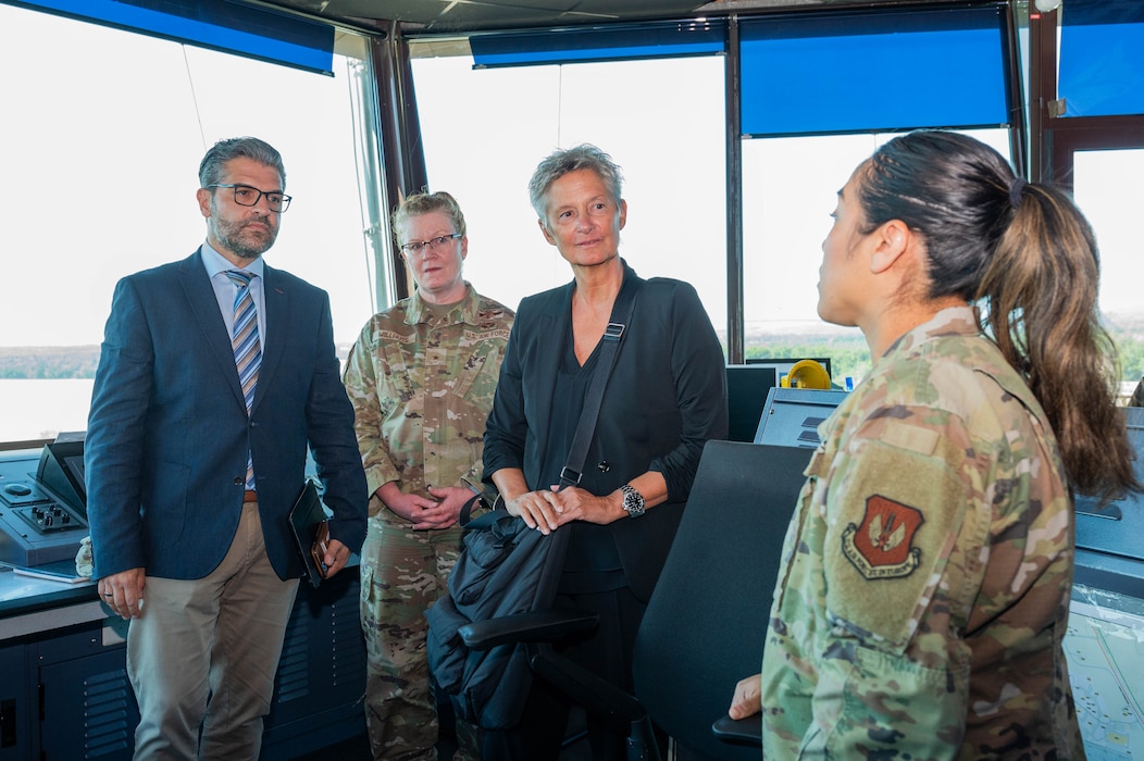 From left, Mr. Roberto M. Saldanha da Costa, 86th Airlift Wing senior host nation advisor, U.S. Air Force Brig. Gen. Adrienne L. Williams, 86th Airlift Wing commander, and Mrs. Beate Kimmel, Lord Mayor of Kaiserslautern, receive a briefing by an Airman assigned to the 86th Operations Support Squadron during a base immersion at Ramstein Air Base, Germany, Aug. 19, 2025.