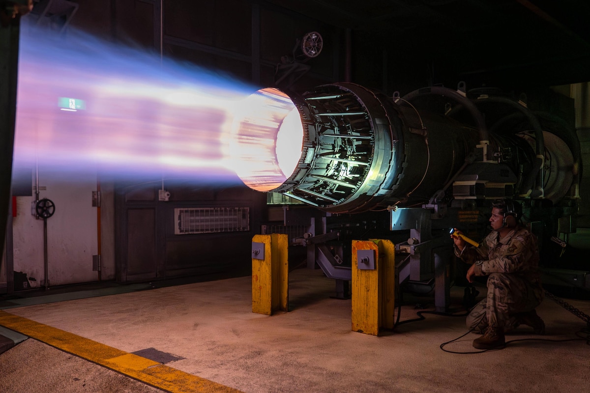 U.S. Air Force Staff Sgt. Ernesto Parra, 18th Component Maintenance Squadron test cell craftsman, inspects a F-15E Strike Eagle engine, the F100-PW-220, during a routine afterburner test at Kadena Air Base, Japan, Aug. 12, 2025. Airmen from the 18th CMS test aircraft engines in a specialized hangar to ensure all components function properly before use. (U.S. Air Force photo by Airman Nathaniel Jackson)