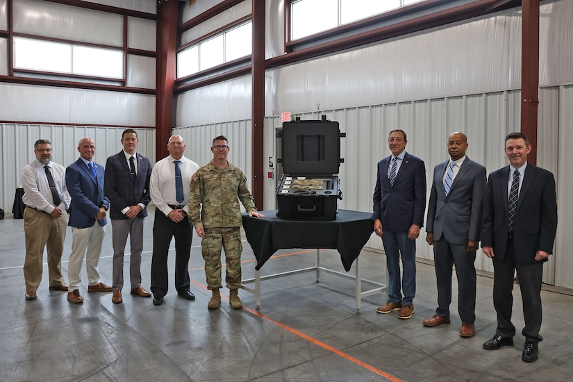 Col. Caleb Lewis (1st left of pelican case), Letterkenny Army Depot commander, and members of the LEAD command team, stand with Mike Pollut (1st right of pelican case), Unmanned Aircraft Systems Logistics Division chief, Dave Carter, UAS Sustainment director, and Ben White, UAS Product Support manager, after the opening ceremony at LEAD on Aug. 20.