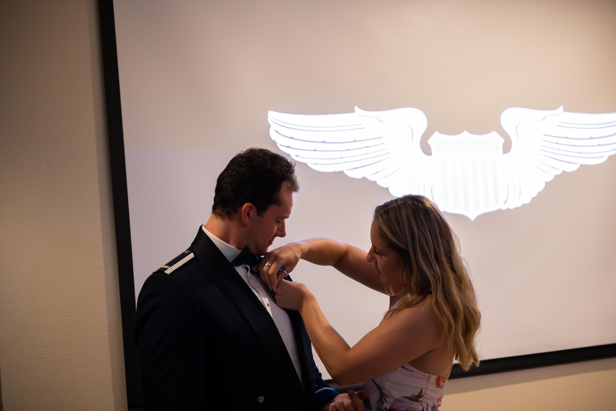 Loved ones pin silver wings on their graduate during a graduation ceremony of Class 25-14 at Laughlin Air Force Base, Texas, Aug. 21, 2025. Twenty-one U.S. Air Force officers were awarded silver wings during the ceremony, symbolizing their completion of the Undergraduate Pilot Training program. (U.S. Air Force photo by Airman 1st Class Harrison Sullivan)