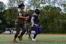 U.S. Marine Corps Sgt. Julie Leon, left, a drill instructor Golf Company, 2nd Recruit Training Battalion, Marine Corps Recruit Depot Parris Island, and a Los Angeles, California native, and Capt. Edgardo Diaz, center, the executive officer of Recruiting Station Boston, encourages a Randolph High School football player during the maneuver under fire portion of a Marine Corps combat fitness test as part of Marine Week Boston, Aug. 21, 2025. During Marine Week Boston, Marines with Marine Corps Recruiting Command shared Marine Corps traditions with local high schools in honor of the Corps’ 250th birthday. Marines stationed across the globe commemorate the 250th anniversary of the Marine Corps, honoring a distinguished legacy of service, sacrifice, and unwavering fidelity to both the nation and fellow Marines. (U.S. Marine Corps photo by Sgt. Aidan Hekker)