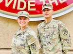 Two Soldiers posing in front of the BJACH sign.